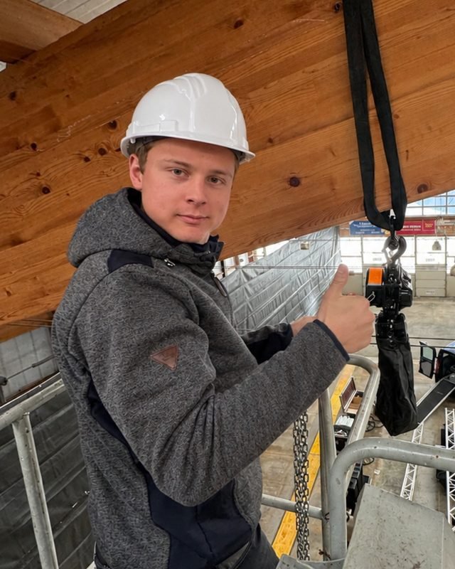 Silvan Bettschen mit Helm auf der Hebebühne beim Aufhängen eines Kettenzugs